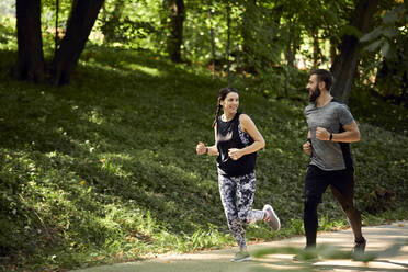 Sporty couple running on forest path - ZEDF02633