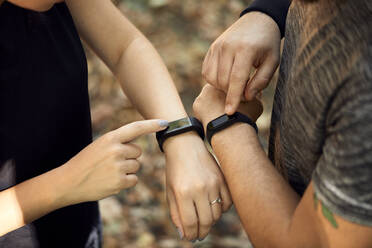 Nahaufnahme eines sportlichen Paares, das Smartwatches überprüft - ZEDF02636
