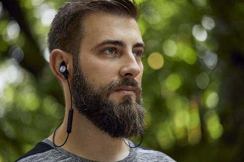 Porträt eines sportlichen Mannes mit Kopfhörern im Wald - ZEDF02641