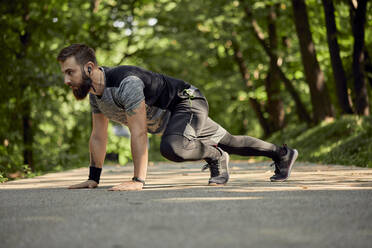 Sportlicher Mann beim Training auf einem Waldweg - ZEDF02647