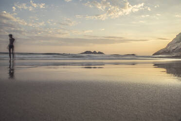 Junge am Meeresufer bei Sonnenuntergang am Strand von Joatinga - CAVF64740