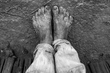 Muddy and barefoot feet of indigenous kid in southern Brazil - CAVF64754