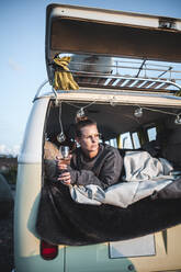 Portrait of woman with glass of white wine in van - NAF00135