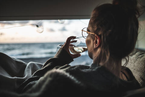 Young woman with glass of white wine in van stock photo