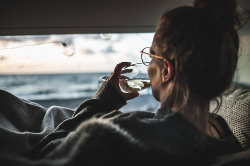 Junge Frau mit einem Glas Weißwein im Lieferwagen - NAF00138