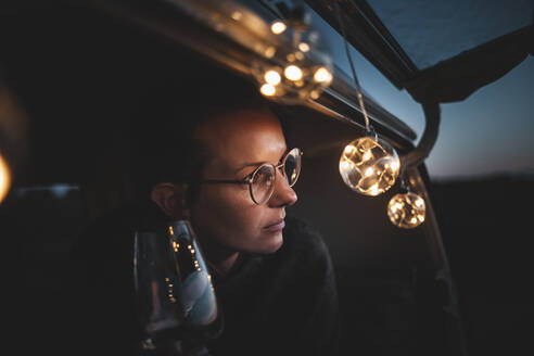 Portrait of young woman with glass of white wine in van - NAF00141