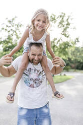 Father carrying happy daughter on his shoulders - STBF00424