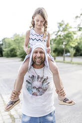 Father carrying playful daughter on his shoulders - STBF00426