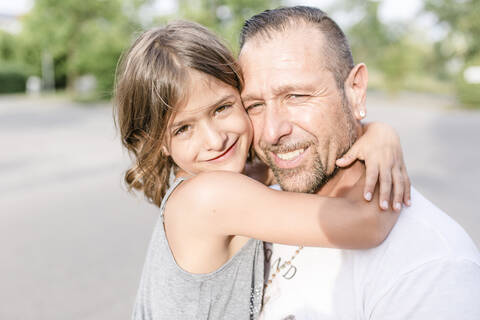 Vater und Tochter umarmen sich im Freien, lizenzfreies Stockfoto