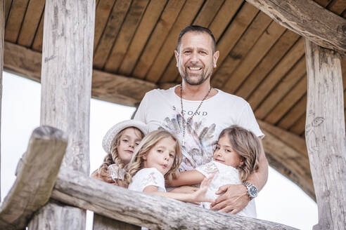 Glücklicher Vater mit drei Drillingsschwestern in einem Baumhaus - STBF00442