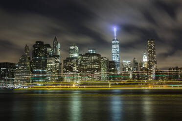 Ferry lights pass by New York's Freedom Tower on the East River. - CAVF64825