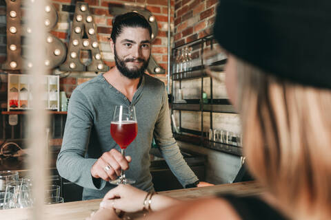 Barkeeper serviert Frau einen Cocktail, lizenzfreies Stockfoto