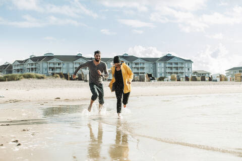 Pärchen beim Laufen am Strand in Heiligenhafen, lizenzfreies Stockfoto