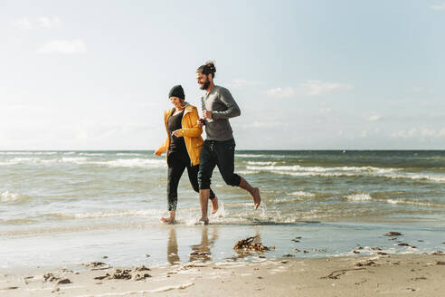 Couple running at the beach in Heiligenhafen - NAF00165