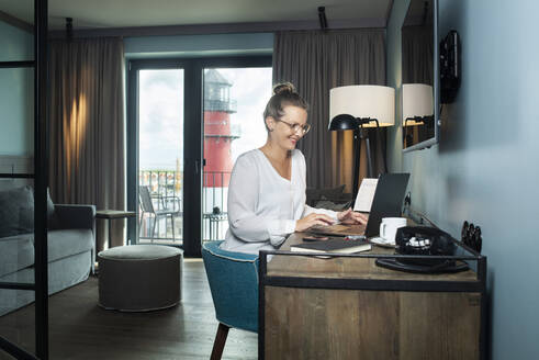 Frau arbeitet in einem Hotelzimmer - NAF00166