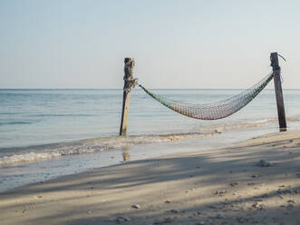 Indonesien, Bali, Gili-Inseln, Gili Air, Fischernetz-Hängematte am Strand an einem ruhigen Tag - KNTF03648