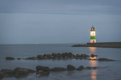 Deutschland, Schleswig-Holstein, Schleimunde, Beleuchteter Leuchtturm von der Küste aus gesehen - KEBF01354
