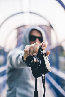 Man with hood holding a camera - CJMF00066