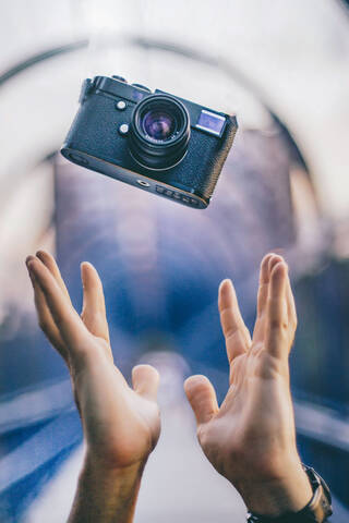 Man hands throwing a vintage camera stock photo