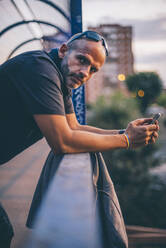 Man with pusera gay flag holding an smartphone - CJMF00071