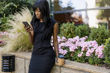 Businesswoman using smartphone in the city - MAUF02916