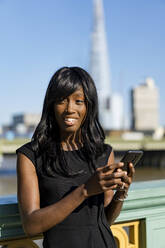 Businesswoman using smartphone in the city - MAUF02932