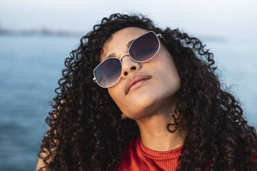 Schöne Frau, mit Sonnenbrille, am Meer stehend - RCPF00039