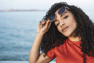 Schöne Frau, mit Sonnenbrille, am Meer stehend - RCPF00045