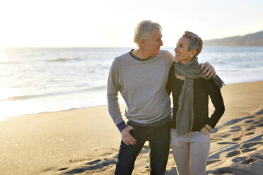 Happy senior couple at beach during sunset - CAVF64961