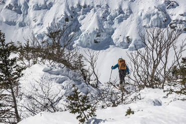 Eine Frau beim Skifahren im frischen Pulverschnee in der Nähe der Tuckerman Ravine am Mount Washington in den White Mountains von New Hampshire. - CAVF65064