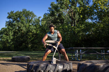 Vorderansicht eines starken, athletischen Mannes, der einen schweren Reifen mit einem Seil zieht - CAVF65068