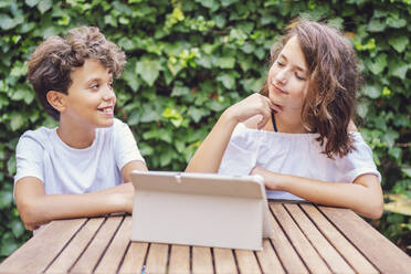 Mädchen und Junge mit Tablet auf Efeu Hintergrund - DLTSF00236