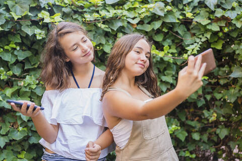 Junge Mädchen nehmen ein Selfie auf Efeu Hintergrund, lizenzfreies Stockfoto