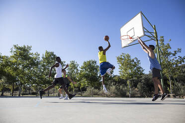 Junge Männer rennen und springen beim Streetballspielen - ABZF02603