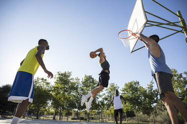 Gruppe von Menschen, die rennen und springen, während sie Streetball spielen - ABZF02605