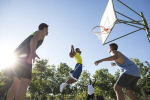 Gruppe von Menschen, die rennen und springen, während sie Streetball spielen - ABZF02606