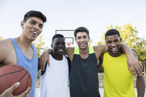 Multiethnische Gruppe von Männern in Sportkleidung mit Basketball auf einem Sportplatz - ABZF02622