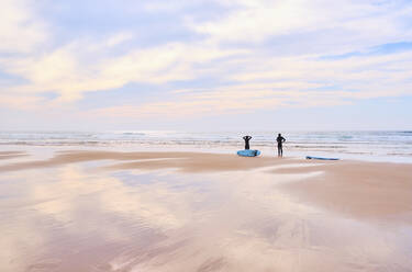 Portugal, Algarve, Silhouetten von zwei Surfern am Strand von Cordoama - MRF02175