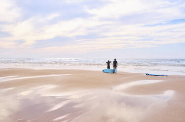 Portugal, Algarve, Silhouetten von zwei Surfern am Strand von Cordoama - MRF02176