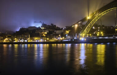 Portugal, Porto, Douro, Beleuchtete Stadt und Dom Luis I Brücke über Wasser gesehen - MRF02215