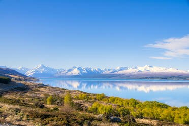 Neuseeland, Südinsel, Blick auf das Ufer des Lake Pukaki mit schneebedeckten Bergen im Hintergrund - SMAF01584