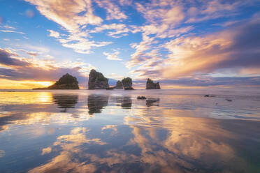 Neuseeland, Südinsel, Wolken und Seeberge spiegeln sich im glänzenden Küstenwasser des Motukiekie Beach bei Sonnenuntergang - SMAF01597