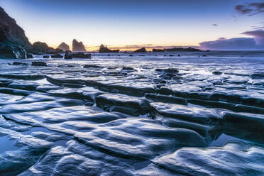 Neuseeland, Südinsel, Felsenküste in der Abenddämmerung mit Motukiekie Beach Meeresfelsen in der Ferne - SMAF01603