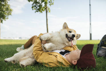 Junge mit Welsh Corgi Pembroke in einem Park - VPIF01588