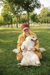 Junge mit Welsh Corgi Pembroke in einem Park - VPIF01592