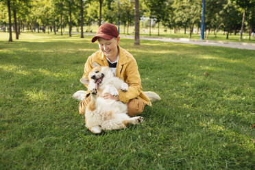 Junge mit Welsh Corgi Pembroke in einem Park - VPIF01594