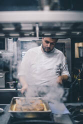 Koch bei der Arbeit in einer Restaurantküche - CJMF00094