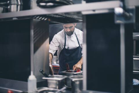 Koch bei der Arbeit in einer Restaurantküche, lizenzfreies Stockfoto