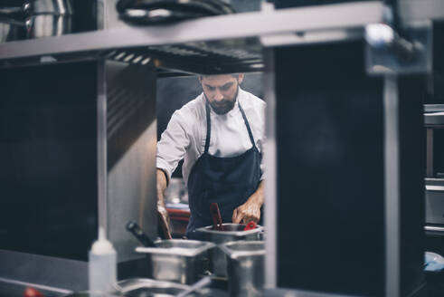 Chef at work in a restaurant kitchen - CJMF00099