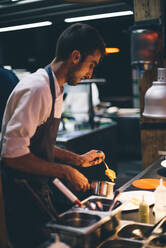 Chef serving food on plates in the kitchen of a restaurant - CJMF00101